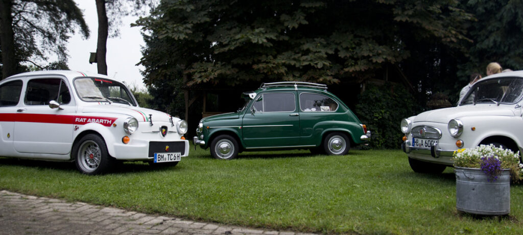 Kreuz und quer stehen die Fiat 600 Freunde im grünen Hof.